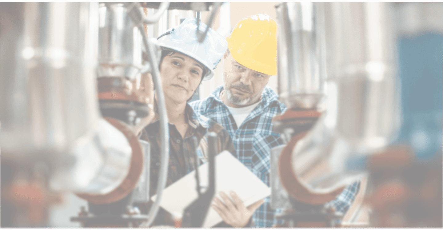 Industrial workers with hard hats examining equipment